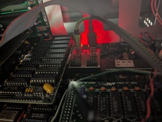 Two One ROM boards glowing red in the PB686's BIOS sockets U41 and U40, each with a USB cable plugged in, among the motherboard's memory chips and ribbon cables